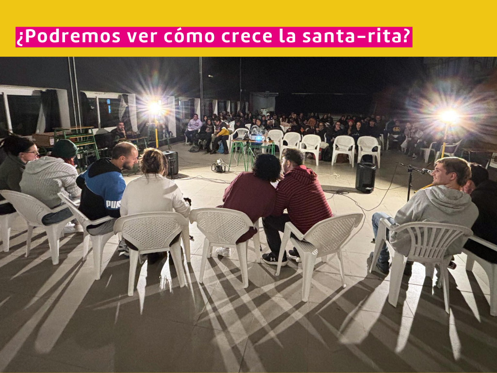 Fotografía de estudiantes en el salón 318 de la Facultad, reunidos durante un evento o clase. Sobre impreso dice: ¿Podremos ver cómo crece la santa-rita?