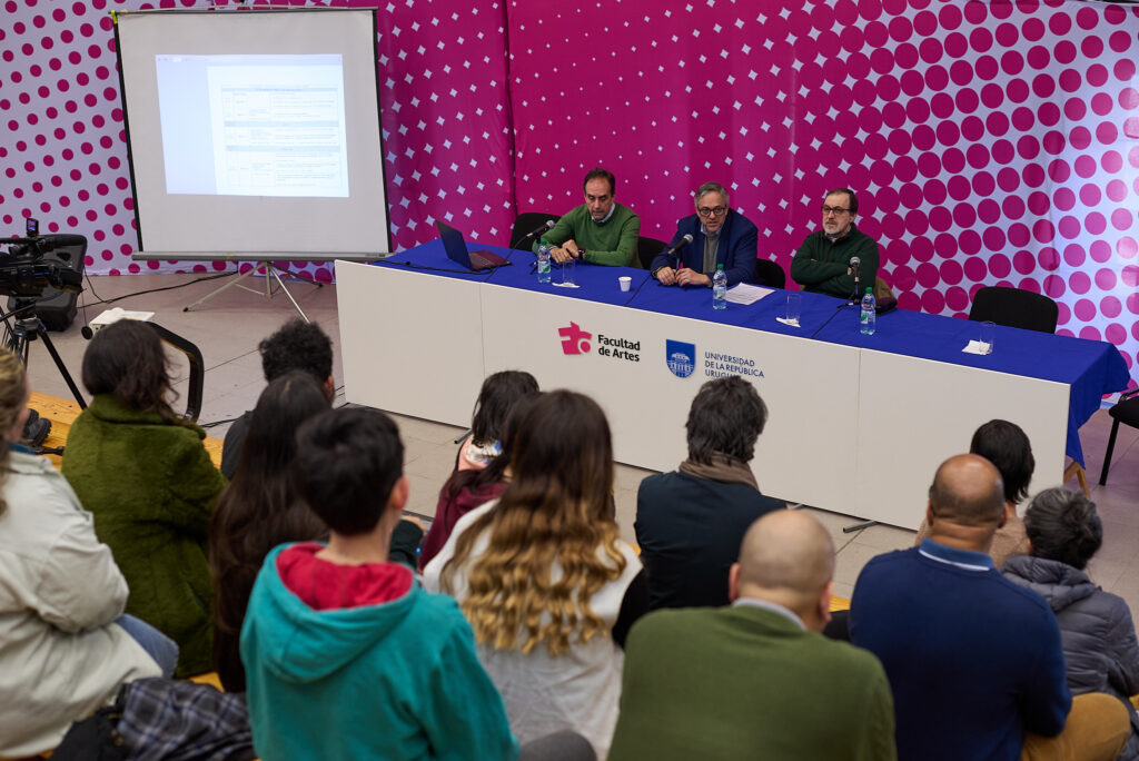 Mesa de oradores en jornada de salud mental con público de espaldas asistiendo