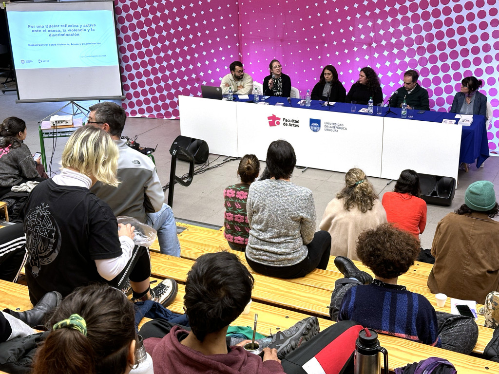 fOTOGRAFÍA donde se ve parte del público asistente de la charla y se ve las personas ordaoras en la mesa: Silva, Pacci, Martínez, Zurdo y Miranda