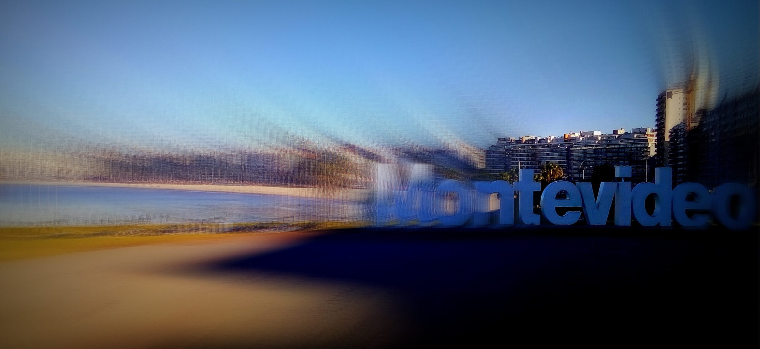 Fotografía de las letras corpóreas que forman la palabra Montevideo, ubicadas en la rambla montevideana. La imagen tiene un efecto de barrido que centra la atención hacia las letras